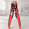 Front view of red and black 5-in-1 automatic wire stripping pliers standing upright on a grey surface.