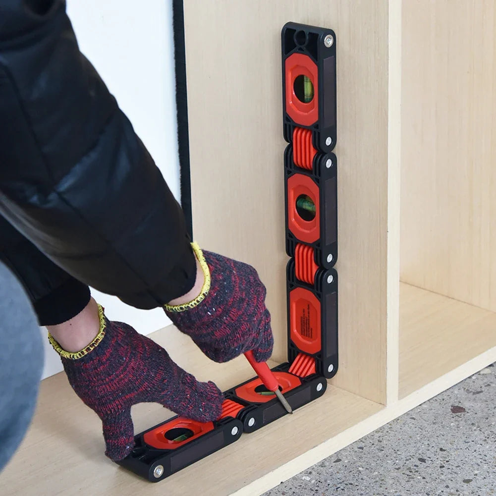 Foldable spirit level bent into a 90-degree right angle to check internal corner alignment inside a wooden shelving unit.
