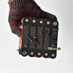 Gloved hand holding the folded magnetic level ruler demonstrating strong magnetic holding power with screws and metal brackets.